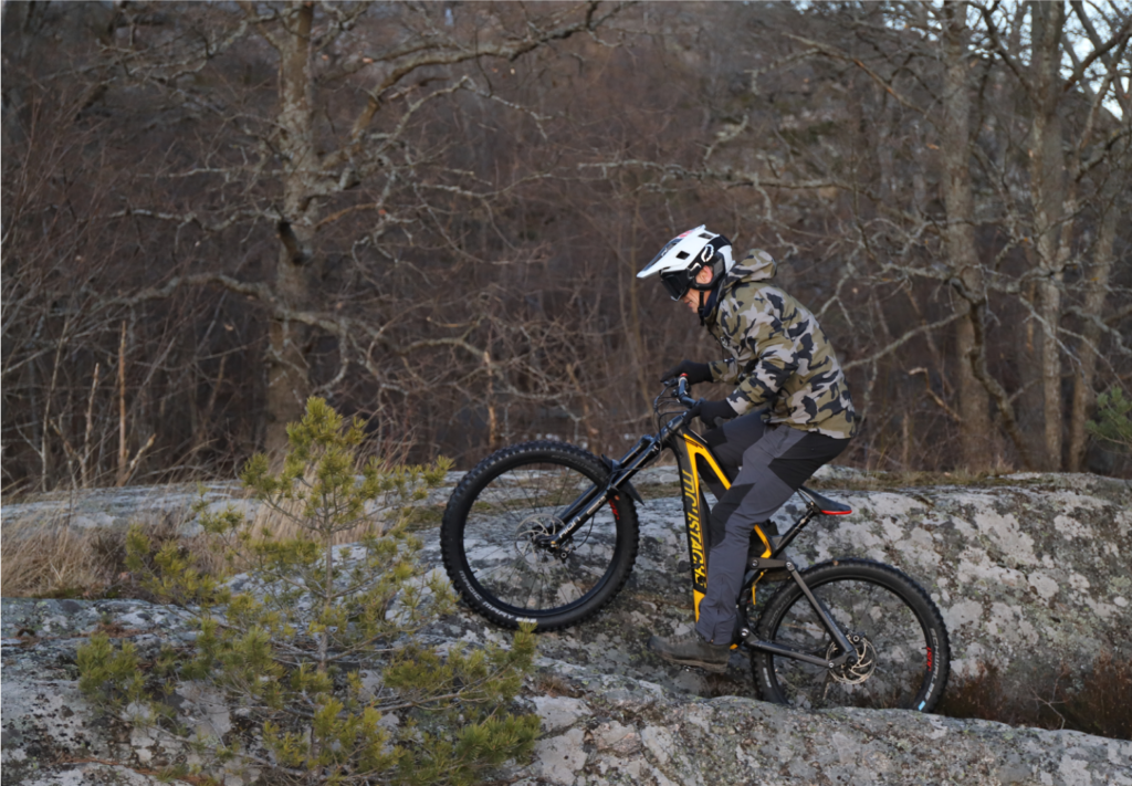 Mountainbiker cyklar uppför klippa