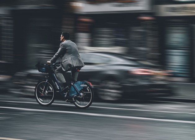 affärsman som cyklar snabbt utan hjälm